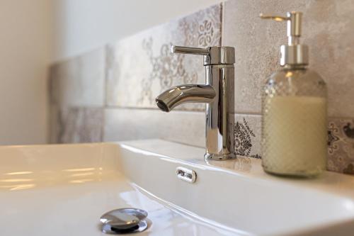 a bathroom sink with a soap dispenser next to it at ESTER'S Szentbékkálla in Szentbékkálla