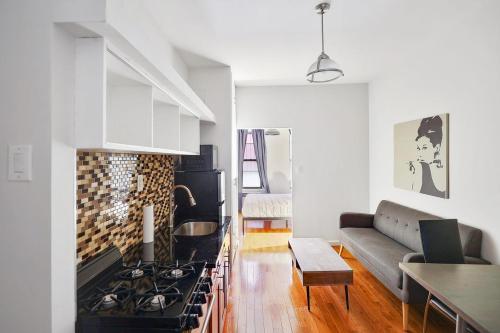 uma cozinha e sala de estar com um fogão e um sofá em Apartment 799: Hells Kitchen em Nova York