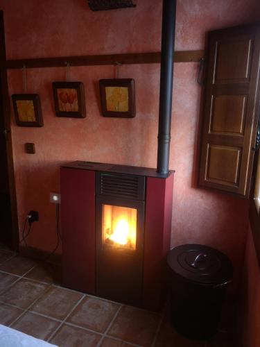 a fireplace in a room with a fire in it at Casita Pirón in Adrada de Pirón