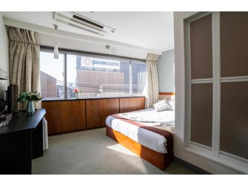 sypialnia z łóżkiem i dużym oknem w obiekcie Tabata Oji Hotel - Vacation STAY 89839v w Tokio