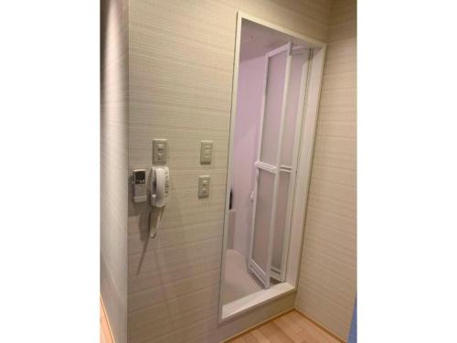 a bathroom door with a phone and a mirror at Tabata Oji Hotel - Vacation STAY 89854v in Tokyo