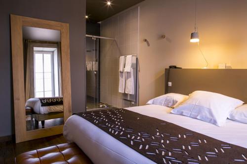 トゥールニュにあるAux Terrassesのベッドルーム(大型ベッド1台付)、バスルームが備わります。