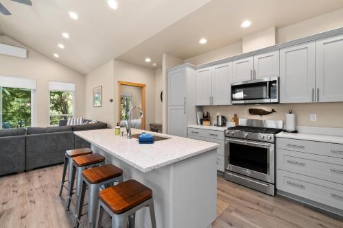 a kitchen with white cabinets and a kitchen island with bar stools at Sand Dollar House MCA#50380 in Manzanita