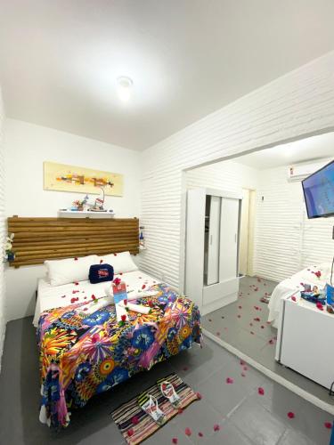a bedroom with a bed with a colorful comforter at Pousada & Food 3 Abelhas in Cumbuco