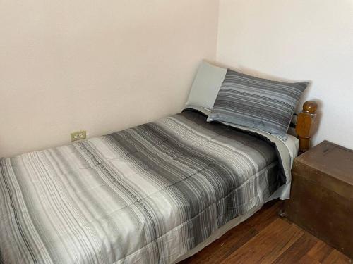 Dormitorio pequeño con cama con manta a rayas en Bonito departamento con dos habitaciones., en Piedras Negras