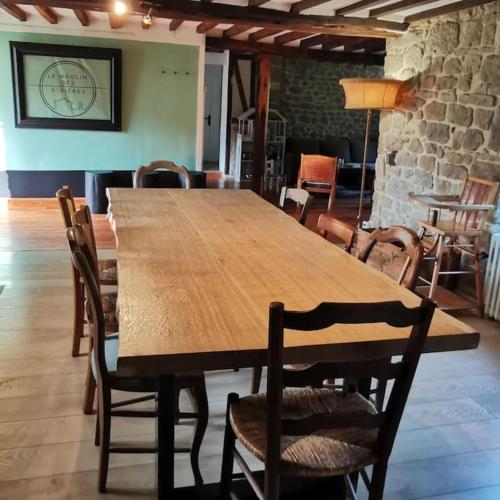 - une table et des chaises en bois dans l'établissement le moulin des riviéres, à Bréel