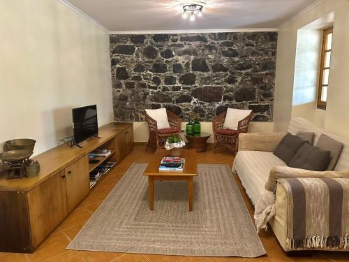 ein Wohnzimmer mit einem Sofa und einem Tisch in der Unterkunft Casa das Ginjas in São Vicente