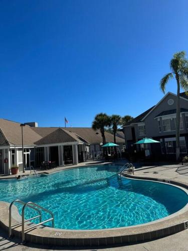 a large swimming pool with blue water in front of buildings at Apartment very Close to Disney! in Orlando