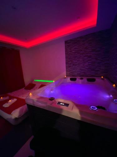 a bathroom with a large tub with a red lighting at Love room in Mondragon