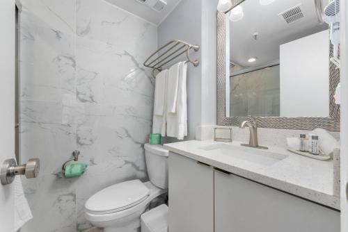 a white bathroom with a toilet and a sink at Apartment in Florida near Universal and Intern. Dr in Orlando