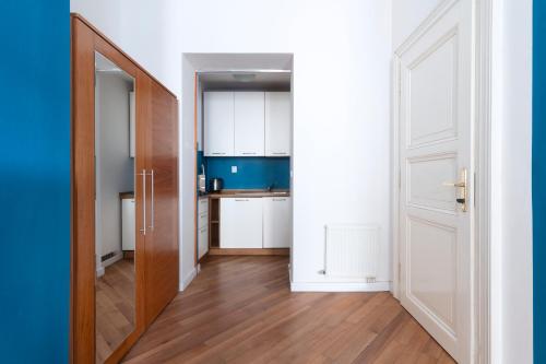 a kitchen with white cabinets and a wooden door at Moonlight Apartments Old Town in Prague