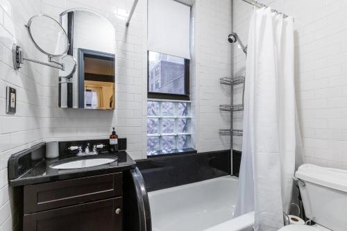 a bathroom with a tub and a sink and a shower at Apartment 282: Columbus Circle in New York