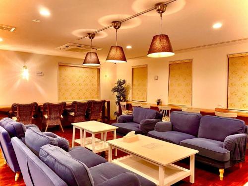 salon z niebieskimi kanapami i stołem w obiekcie HOTEL SANDRIVER ISHIGAKIJIMA - Vacation STAY 91454v w mieście Ishigaki