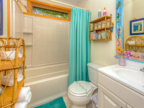 a bathroom with a toilet and a shower and a sink at Lil Love Shack in Manzanita