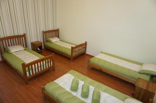 three beds in a room with wooden floors at Holiday Apartment in Alūksne