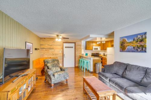 a living room with a couch and a kitchen at Brian Head Ski Condo - Walk to Giant Steps Lift! in Brian Head