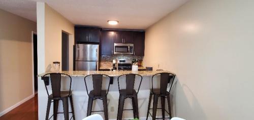 a kitchen with a counter with four bar stools at Wonderful 3BR apartment in NYC! in New York
