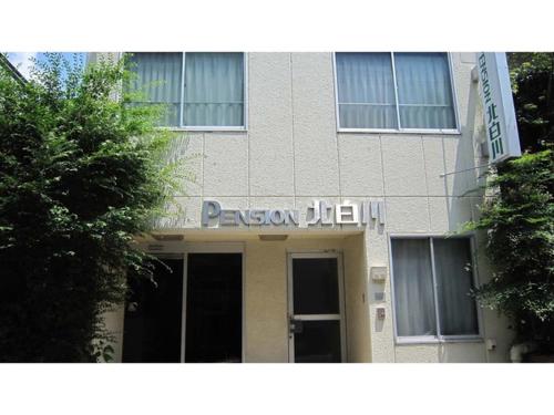 a tan building with a sign on top of it at Pension Kitashirakawa - Vacation STAY 91686v in Kyoto