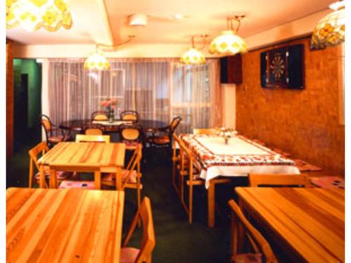 comedor con mesas y sillas de madera en Pension Kitashirakawa - Vacation STAY 91714v en Kioto