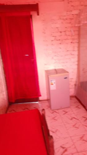 a room with a red door and a small refrigerator at Villa CALLI in Sambava