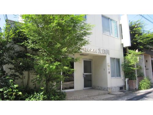 ein weißes Gebäude mit einem Baum davor in der Unterkunft Pension Kitashirakawa - Vacation STAY 91703v in Kyoto