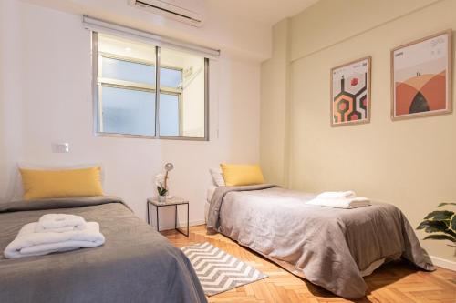 1 dormitorio con 2 camas y ventana en Fliphaus Cordoba 2500 - 3 Bd Facultad Medicina en Buenos Aires