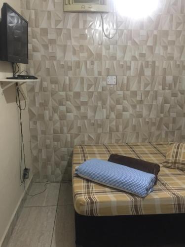 um quarto com uma cama e uma televisão na parede em Pousada Familia Aparecida em Aparecida