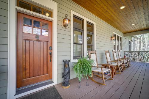 a front porch with a wooden door and chairs at Sapphire Vacation Rental Less Than 1 Mi to Whisper Lake! in Sapphire