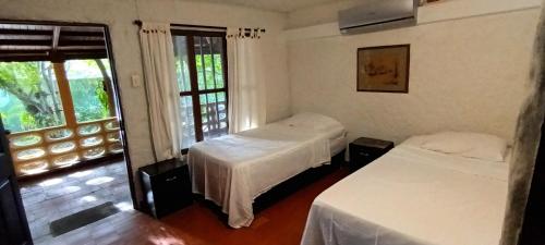 two beds in a room with a window at Villa Margarita in Puerto Colombia