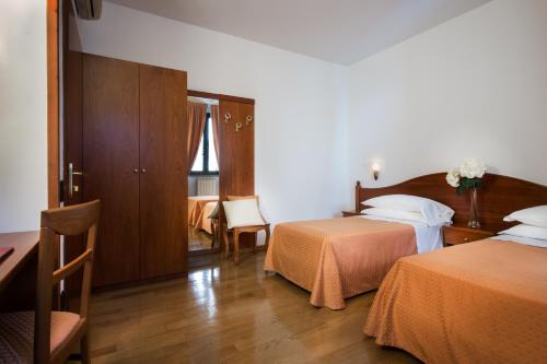 una camera d'albergo con due letti e un tavolo di Hotel La Villetta a Calenzano