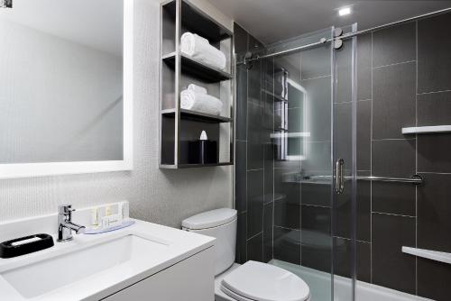 a bathroom with a shower and a toilet and a sink at TownePlace Suites by Marriott New York Manhattan/Times Square in New York