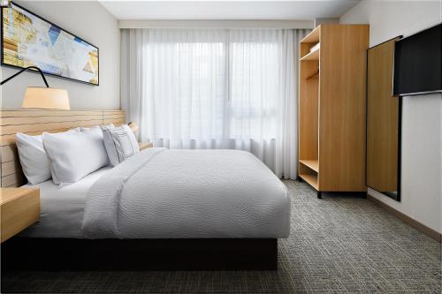 a hotel room with a bed and a television at TownePlace Suites by Marriott New York Manhattan/Times Square in New York
