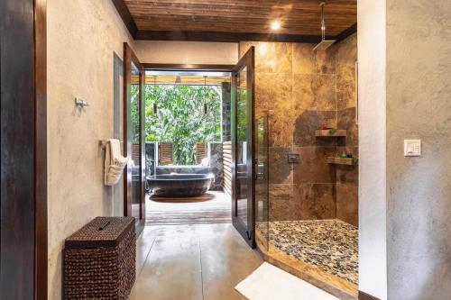 La salle de bains est pourvue d'une douche à l'italienne et d'une baignoire. dans l'établissement Valley Stream Private Eden, à Good Living Camp