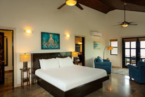 a bedroom with a bed and two blue chairs at 3 Story Oceanfront Luxury Villa 5 Bedroom w Pool in Maya Beach