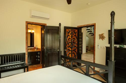a room with a bed and a tv and a mirror at 3 Story Oceanfront Luxury Villa 5 Bedroom w Pool in Maya Beach