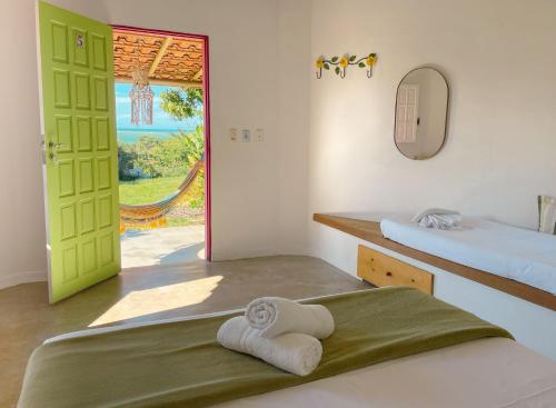 a room with two beds and a door with a window at Canto do Mar - Chalés com vista pro Mar - Cumuruxatiba in Cumuruxatiba