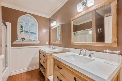 a bathroom with two sinks and a large mirror at ৎ୭Paradise Louiseৎ୭ Pool, Jacuzzi, huge yard &More in Los Angeles