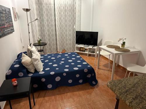 a room with a bed and a table and a tv at Acogedor apartamento en Playa De Santiago in Alajeró