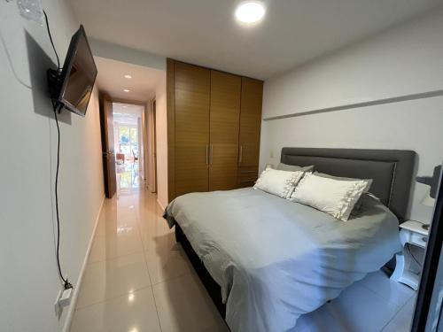 a bedroom with a bed and a tv on a wall at Park City Buenos Aires in Buenos Aires