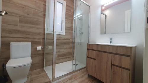 a bathroom with a toilet and a glass shower at Apartamento nuevo en Terrassa Centro in Terrassa