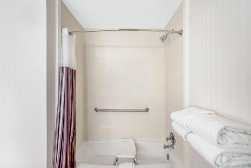 a white bathroom with a shower and a toilet at La Quinta by Wyndham Columbus MS in Columbus