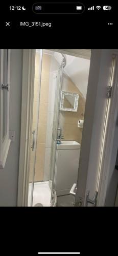 a bathroom with a shower with a toilet and a sink at ST Anthony Ensuite Room in Woolwich