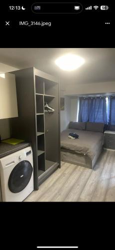 a small room with a bed and a washing machine at ST Anthony Ensuite Room in Woolwich