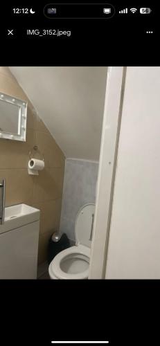 a bathroom with a white toilet and a sink at ST Anthony Ensuite Room in Woolwich