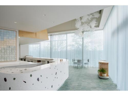 cocina blanca con encimera y mesa en ITOMACHI HOTEL 0 - Vacation STAY 97807v, en Saijo