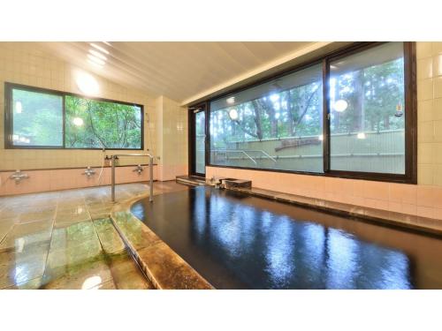 einen Pool mit Wasser in einem Zimmer mit Fenstern in der Unterkunft Oyado Kotobuki - Vacation STAY 97600v in Yokokura