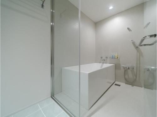 un bagno bianco con doccia e porta in vetro di ITOMACHI HOTEL 0 - Vacation STAY 97815v a Saijo