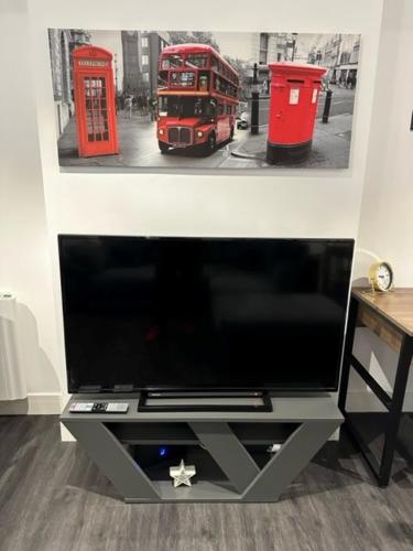 a television with a picture of a double decker bus at Stunning Flat with Parking Free near Sutton Station in Cheam