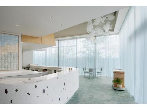 a white kitchen with a counter and a table at ITOMACHI HOTEL 0 - Vacation STAY 97802v in Saijo