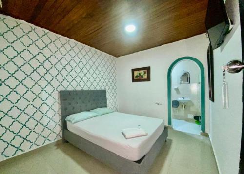 a small bedroom with a bed and a mirror at HOTEL SANTA MONICA in Barranquilla